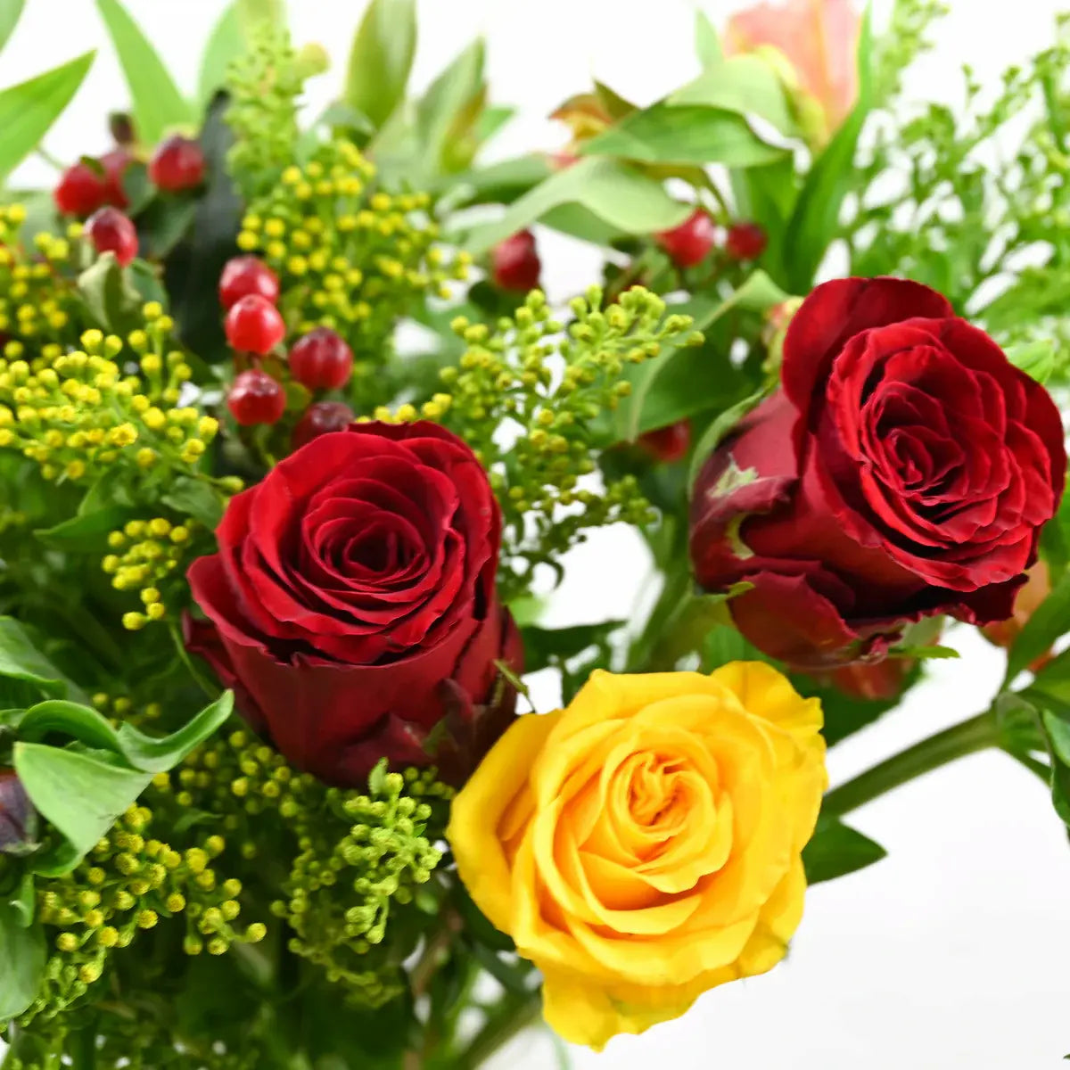 Close-up detail red roses, yellow rose, green yellow solidago clusters, red berry accents
