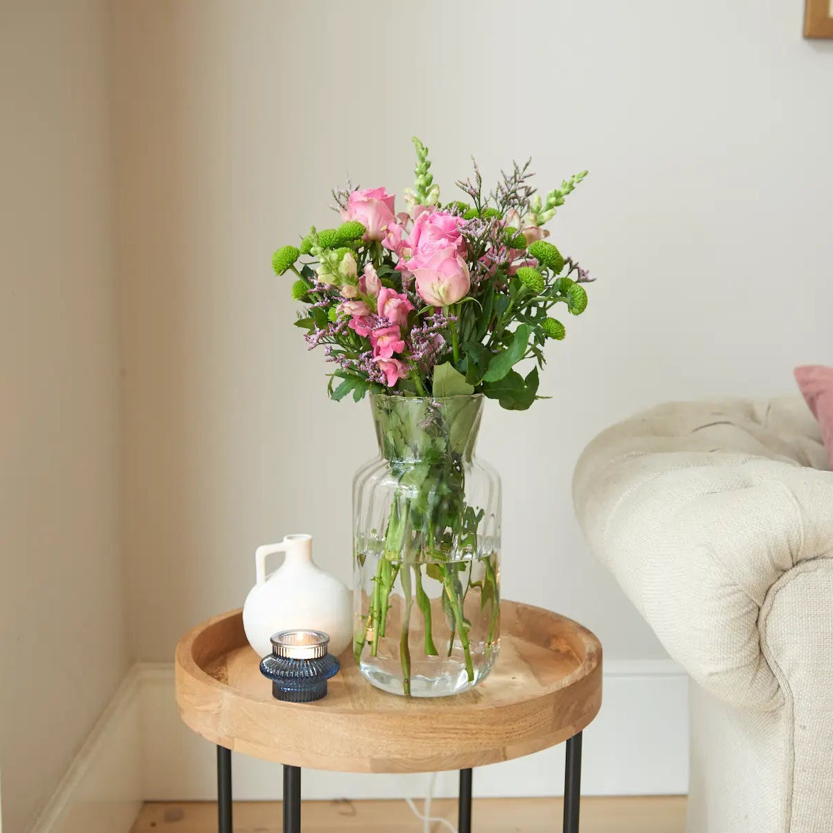 pink-rose-antirrhinum-limonium-santini-bouquet-in-glass-vase-on-wooden-table